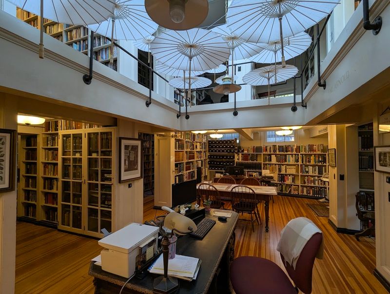 The Warm Glow Of A Chandelier Over Endless Shelves