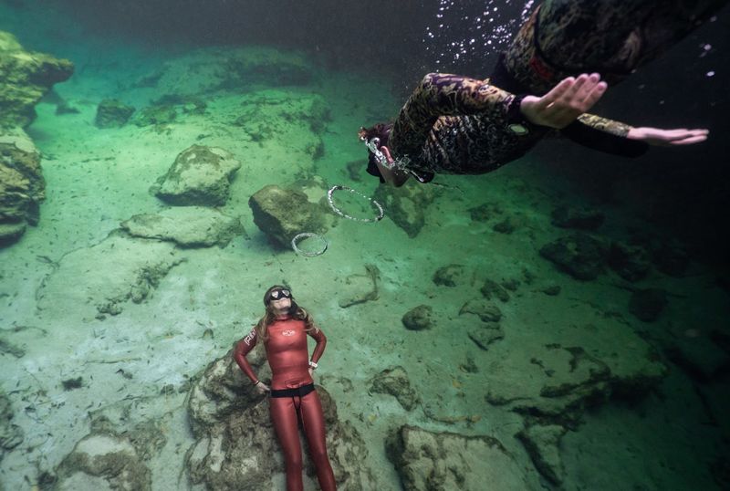 Scuba Divers Explore The Bridge At The Lake Bottom
