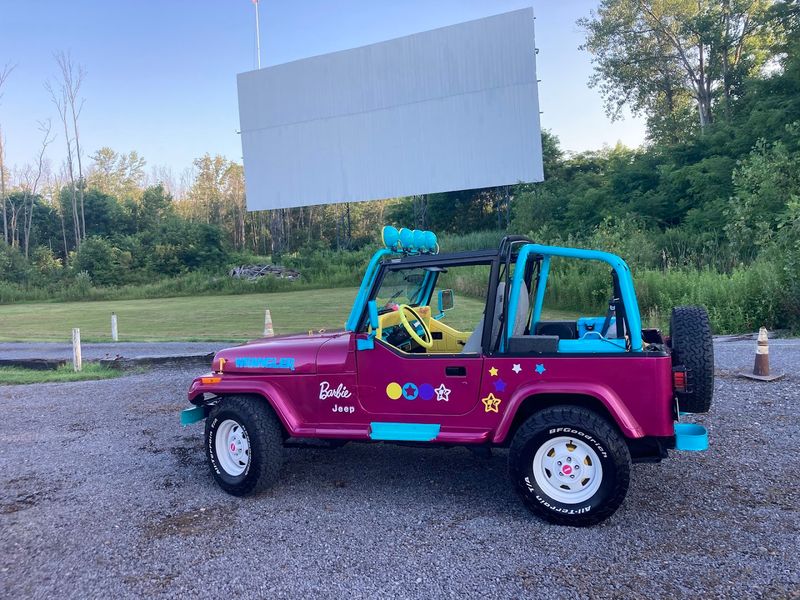 A Jurassic Park Jeep Hiding Among The Wooded Background
