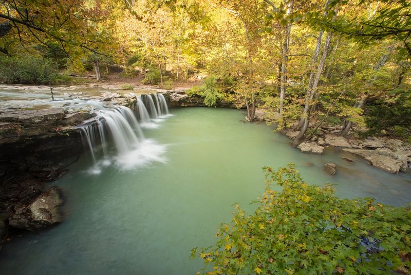 A Secluded Emerald Pool Surrounded By Mossy Rocks