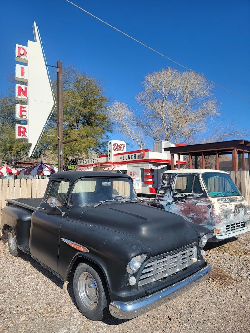 Classic Cars Parked Along A Gravel Drive