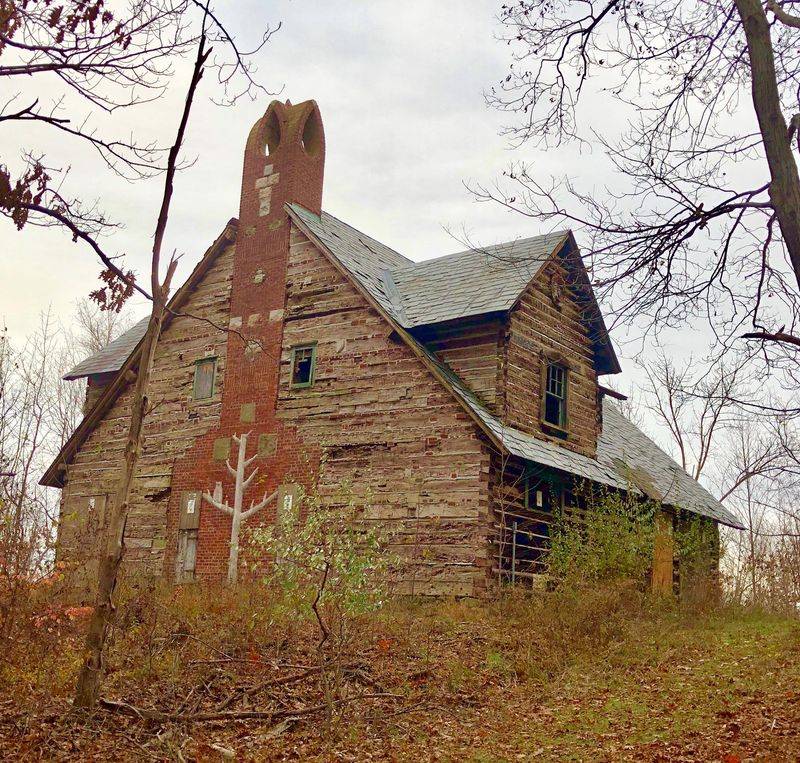 A Log Cabin With Stone Animal Carvings