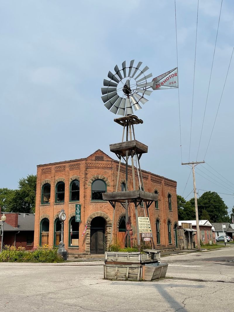 Wandering Brick Sidewalks Past A Windmill In The Road